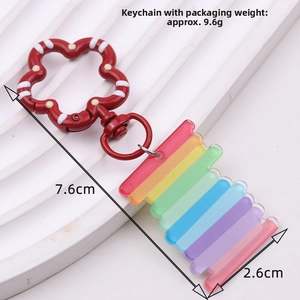 Rainbow acrylic keychain with red polka dot flower clasp showing 7.6cm length and 2.6cm width