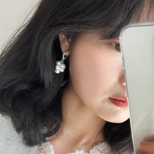 Model wearing elegant cluster earrings with white freshwater pearls and silver hooks