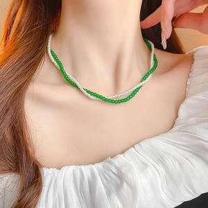 Close-up of double-layer beaded necklace with green glass beads and white pearls on neck