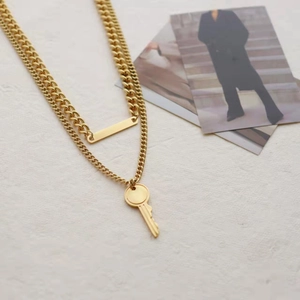 Double-layered golden titanium steel necklace featuring key and rectangular pendants