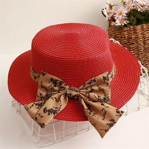 Red flat-top straw hat with floral print ribbon bow for summer beach sun protection