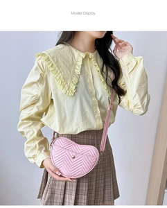Detail of pink heart-shaped crossbody bag with chevron quilting and golden metal hardware