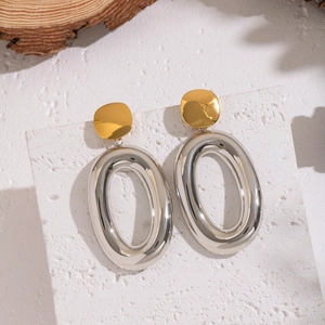 Two-tone oval drop earrings in 18K gold and silver stainless steel on textured stone