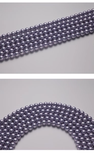 Detailed view of round lavender imitation pearls with high metallic luster and pre-drilled holes