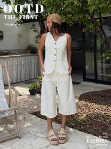 Detail of white two-piece summer set with V-neck button vest and high waist wide-leg pants