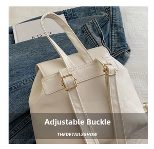 Close-up of white PU leather backpack strap with gold metal adjustable buckle detail