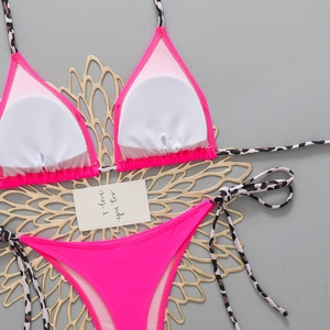 Flat lay of pink bikini set with leopard print straps and removable chest pads