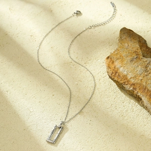 Detailed view of silver stainless steel necklace with textured rectangular hollow pendant