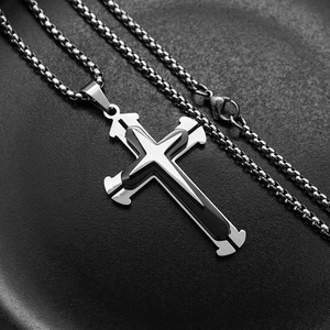 Close-up of a three-layer stainless steel cross pendant with a black inner layer