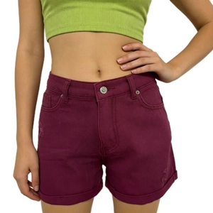 Dettaglio degli shorts in denim bordeaux con risvolto e finitura usurata sull'orlo