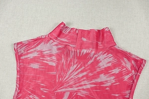 Detailaufnahme des rosa Kleides mit Stehkragen, abstraktem Druck und feiner Stoffstruktur
