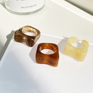 Three minimalist square resin rings in amber, marble brown, and yellow clear colors