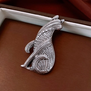 Detailed macro view of the cat-shaped silver brooch showing woven metal texture