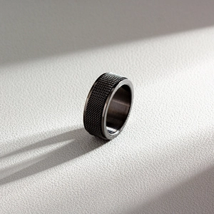 Detail shot of a 8mm gunmetal spinner ring featuring a textured knurled finish for men