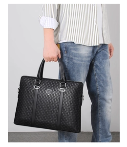 Detail of black leather business briefcase with embossed texture and metal hardware