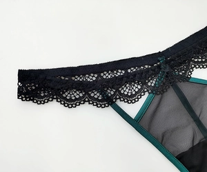 Dettaglio del pizzo floreale verde scuro e della rete trasparente per donna