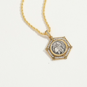 Detailed close-up of a two-tone hexagonal pendant featuring an embossed portrait relief