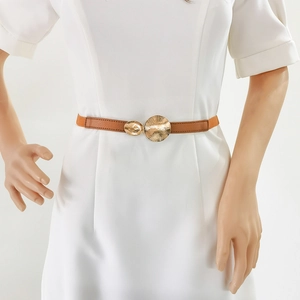 Detail of thin brown waist belt featuring golden dual-ring buckles with sunburst texture