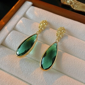 Vintage emerald green teardrop earrings with gold irregular studs in a white box