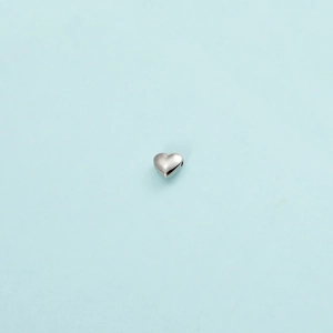 Close-up of polished stainless steel heart bead with a 1mm hole for jewelry making