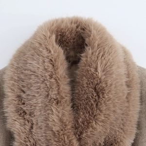 Détail du col en fausse fourrure du manteau noir en laine avec texture marron chaud