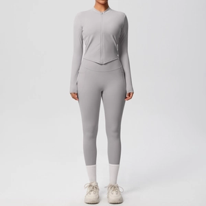 Vue détaillée d'un ensemble yoga gris avec veste zippée courte à ourlet en V et legging taille haute