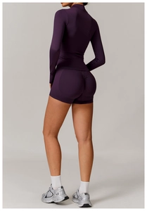 Detail of dark purple compression sports set featuring stand collar zip-up and shorts