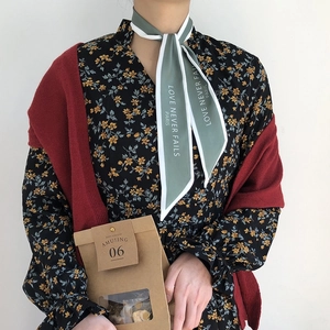 Detail of French vintage silk scarf with Love Never Fails text and paper bag packaging