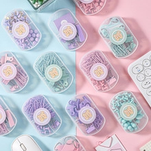 Close-up of pastel stationery sets with binder clips and pins in macaron gift boxes