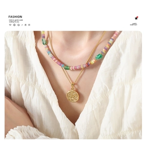 Détail d'un collier multicouche avec perles colorées et pendentif à relief floral doré