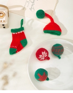Detailed close-up of knitted Christmas ornaments featuring socks, hats and patterned spheres