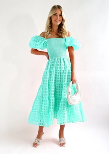 Detail of mint green off-shoulder dress featuring ruffled bodice and textured mesh fabric