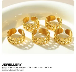 Set of five gold-plated double-layer link chain rings on a minimalist white ceramic tray
