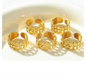 Set of five gold-plated double-layer link chain rings on a minimalist white ceramic tray