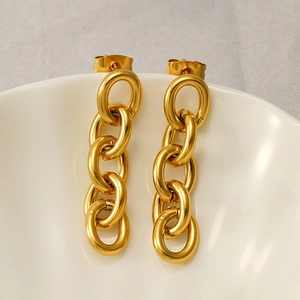 Gros plan de boucles d'oreilles en acier inoxydable plaqué or 18K sur plat en céramique