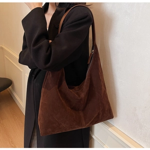 Brown suede large hobo bag with leather strap shown in a minimal indoor setting