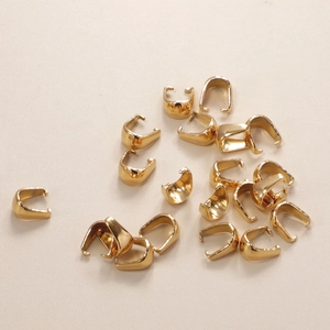 Macro shot of 16 pieces golden stainless steel U-shape pinch bails for jewelry making
