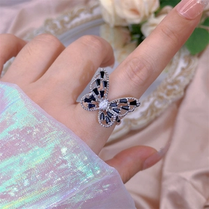Detailed view of silver butterfly ring featuring black cubic zirconia and open design