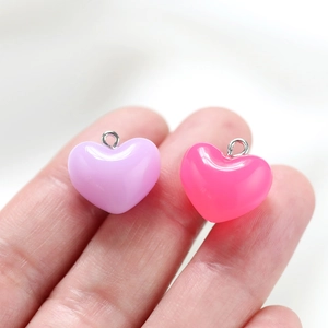 Close-up of heart-shaped acrylic pendants in lavender and pink for DIY jewelry