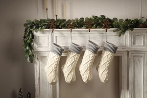 Macro detail of cable knit Christmas stockings hanging on a white fireplace mantel