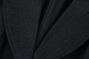 Detail shot of heavy wool coat fabric with smooth silk lining and precise stitching