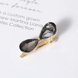 Detail of golden hairpin with dual drop-shaped grey crystals on an elegant background