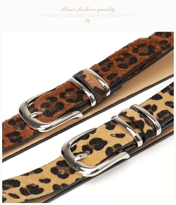Detalle de cinturones con estampado de leopardo y hebillas ovaladas de metal plateado