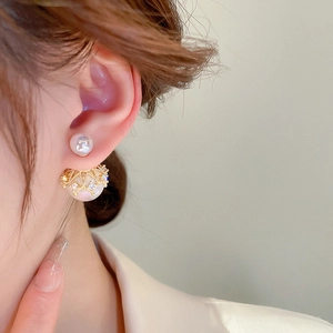 Macro detail of gold crown pearl earring featuring sparkling zircon and refined craftsmanship