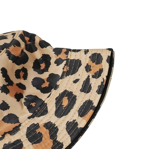Detail of leopard print bucket hat with gold stitching and satin texture fabric