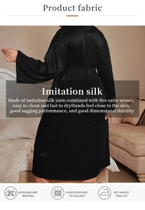 Detail of black imitation silk robe with leopard pattern texture and elegant tie waist
