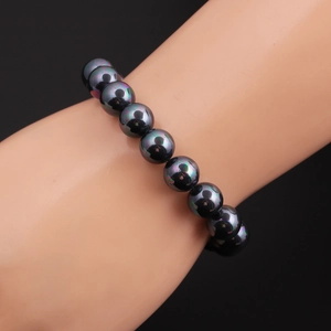 Detailed close-up of 10mm iridescent rainbow hematite bead bracelet on a model wrist
