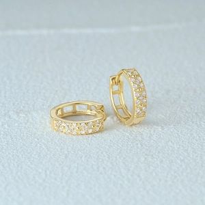 Close-up of gold-plated S925 sterling silver hoop earrings with small diamond accents
