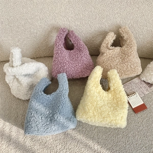 Plush faux shearling wrist bags displayed in five soft pastel colors for a cozy look