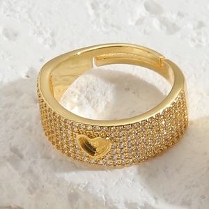 Macro shot of gold heart ring with micro-paved cubic zirconia on textured background